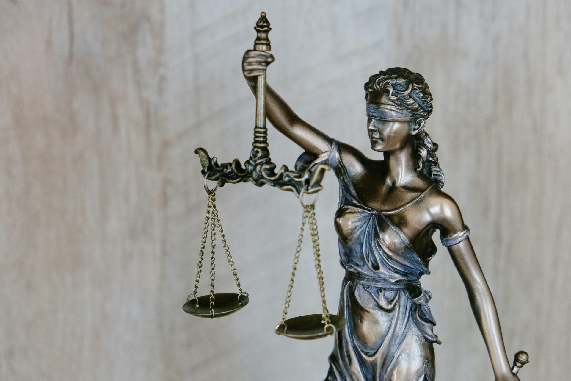 Statue of Lady Justice holding scales while blindfolded.